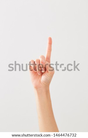 Female hands counting number 1 or raised index finger on white background