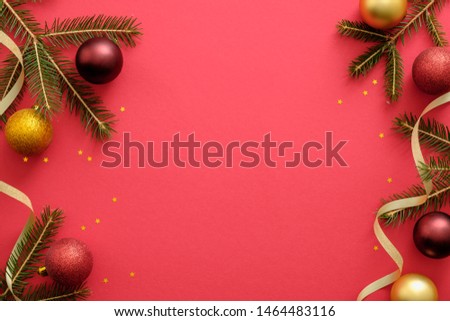 Christmas composition. Christmas red and golden decorations, fir tree branches on red background. Flat lay, top view, copy space. Xmas or New Year frame, banner template mockup. 