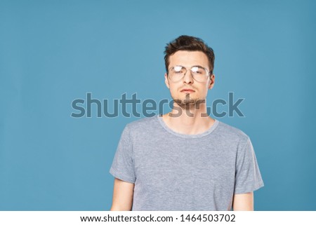 Handsome man gray t-shirt glasses blue fashion background