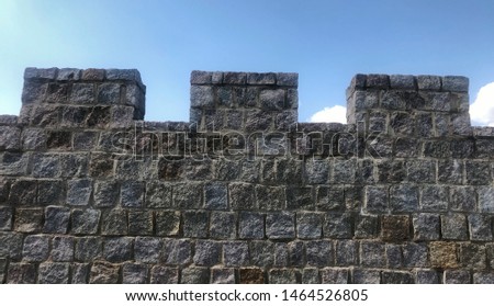 fortified castle wall on background blue sky Royalty-Free Stock Photo #1464526805