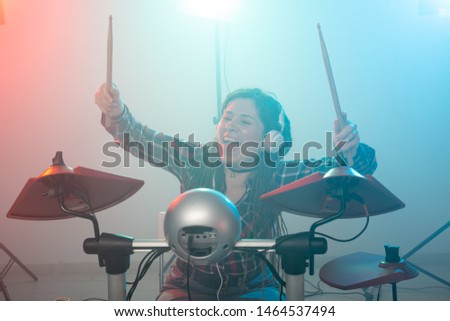 Music, electronic drum set and hobby concept - woman drummer in a recording studio