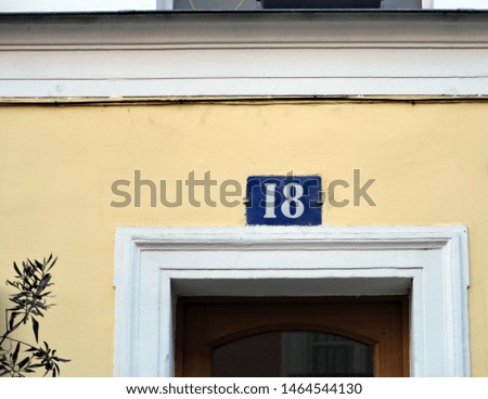 Number 18 , street number plate on a facade.