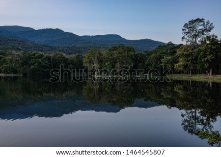 Scenic landscape of mountains valley covered with forest with lake reflection in the cloudy day with morning sunlight at hiking trails viewpoint of Thailand