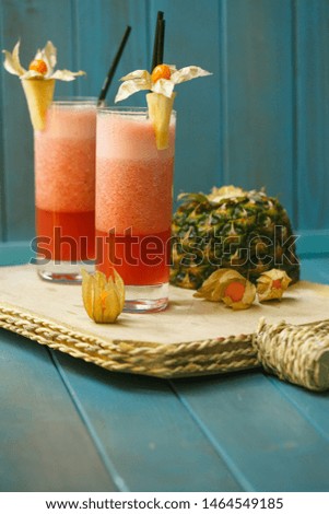 frozen pineapple cocktails garnished with pineapple and physalis on wooden board