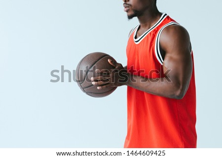 cropped view of african american sportsman holding basketball ball isolated on grey