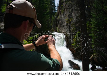 Hiker taking pictures of a waterfall