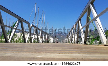 Floating pier on the blue sea background. Travel or vacation destination. Pontoon bridge for boarding ships. Close-up showing detail of wooden walk way that floating