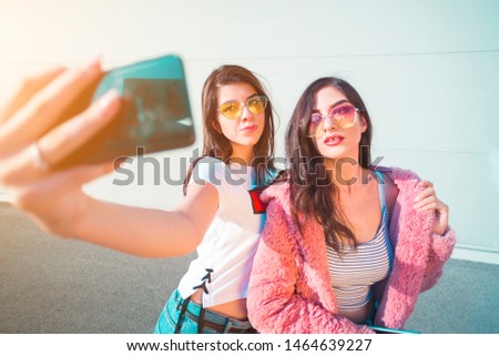 Two beautiful young women taking a selfie