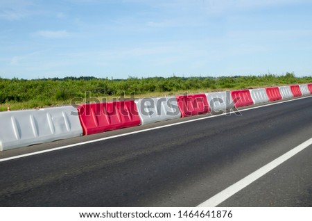 plastic red and white fences on the road on the highway, on the ring road in the modern city. roadside signs for car drivers. dividing strip. 