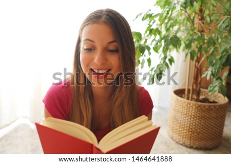 Young pretty woman sitting and reading a book enjoys of rest