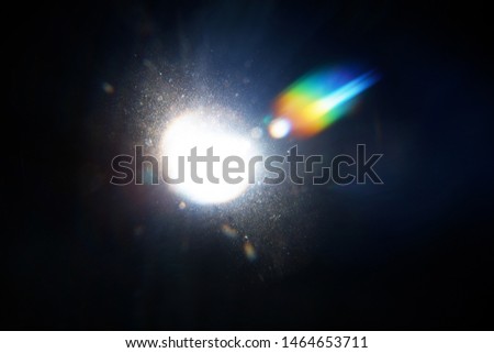 Lens Flare. Light over black background. Easy to add overlay or screen filter over photos. Abstract sun burst with digital lens flare background. Gleams rounded and hexagonal shapes, rainbow halo, blur