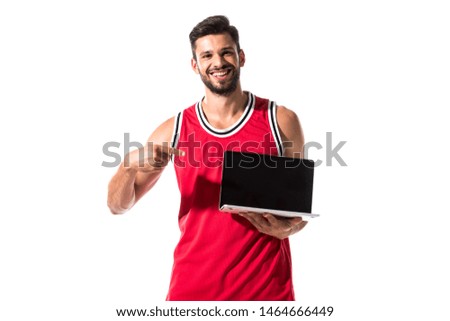 happy athletic basketball player pointing with finger at laptop Isolated On White 