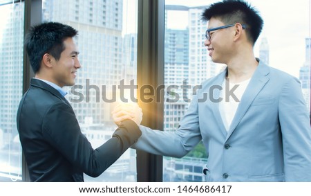 Two Asian business men is making handshake for business dealing