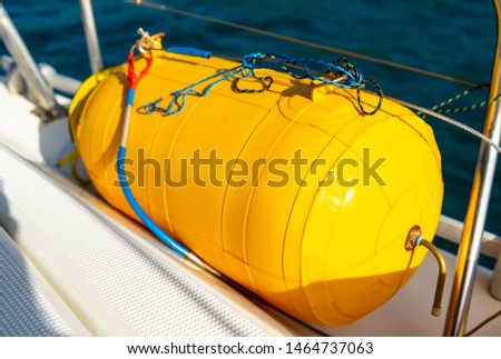 Rescue diving buoy on a sailing yacht. Buoy for spearfishing on a yacht during a cruise on the Andaman Sea from Langkawi Island in Malaysia to Phuket in Thailand. Bright yellow water sport accessory