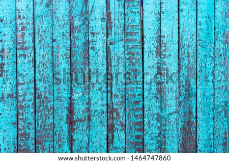 Blue old painted peeling vertical fence boards.  Front view.  Textured background.