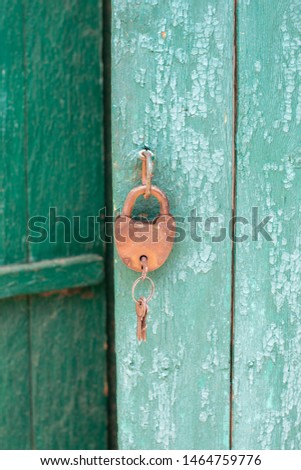 
old iron lock with keys on a wooden door background