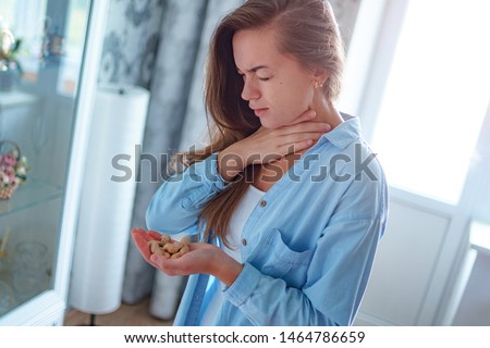Young sick unwell woman suffers from choking and cough from allergic reaction to peanut. Danger of nuts allergy Royalty-Free Stock Photo #1464786659