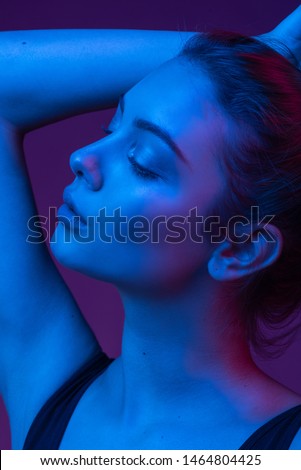 Very beautiful girl. Gorgeous brunette with plump natural lips. Portrait of a girl in the studio with color filters. Portrait, fashion, beauty, glow. Perfect profile of an interesting woman. Closed.