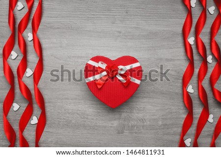 Gift box in the form of a heart. Ribbons in the form of a spiral and decorative heart. Place for text. Holiday concept. Background, top view.