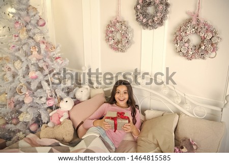 little child girl with xmas present. The morning before Xmas. Sleep. small girl relax at home. christmas family holiday. happy new year. Christmas shopping. Opening her Christmas present.