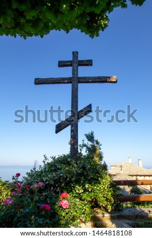 Huge wooden Orthodox eight-pointed cross against the sky after the dawn on Mount Athos