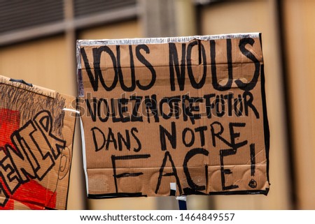 French placard held at ecological rally. A French sign saying you rob us of our future in our face is held by an environmental protestor during a demonstration in Montreal, Canada.