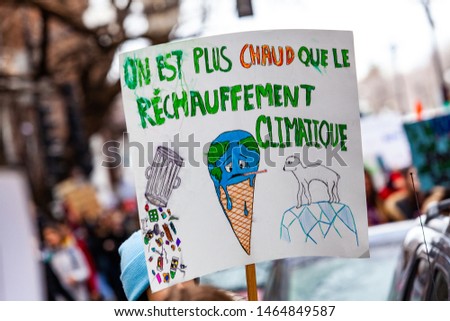 French placard against climate change. A closeup view of a French sign saying we are hotter than global warming and a picture of planet earth melting, held by an ecological activist during a protest.