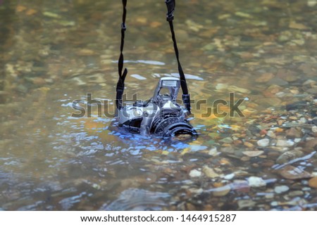 SLR camera submerged on the river. concept of waterproof devices and equipment