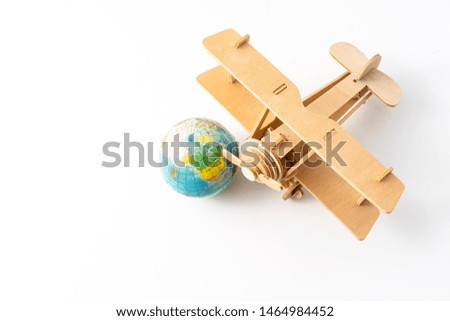 Miniature wooden aeroplane with a mini globe. Travel concept