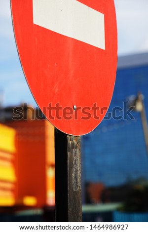Traffic warning signs are erected at the entrance of the road, and the sun shines on the red one-way sign prohibiting entry. It is forbidden to drive the car into the passage.