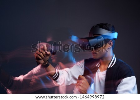 a man using VR glasses fighting experience, movement and blur photography technique second curtain flash