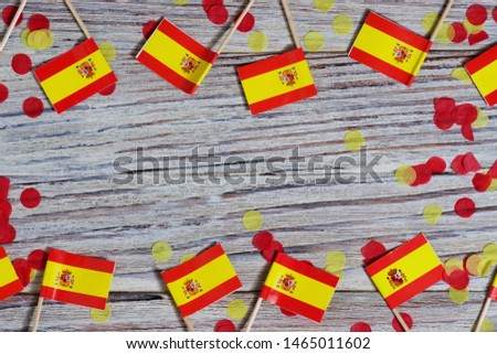 Independence Day of Spain concept with flag in hand on white wooden background top view