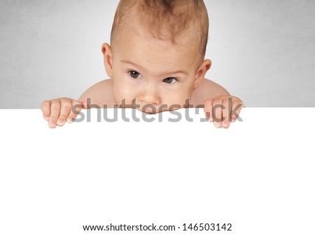 Baby holding white blank paper with her mouth and hands