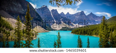 Moraine lake, Banff National Park, Calgary, Alberta, Canada.  An amazing picture of Moraine lake with it's aqua colored water, framed by a forest of trees, mountains, glaciers, snow and clouds