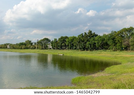 Grasslands and trees arranged along the lake. Riverside and bright sky views at Nongbon water sports center Bangkok Thailand.