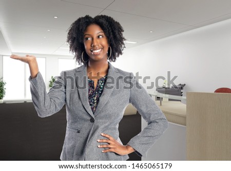 Black African American businesswoman in an office advertising or presenting something.  She is an owner or an executive of the workplace.  Depicts careers and startup business. 