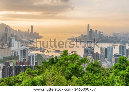 Unusual view of Hong Kong skyline and Victoria harbor at sunset. Skyscrapers in downtown are visible on orange sky background. Awesome cityscape. Hong Kong is popular tourist destination of Asia.