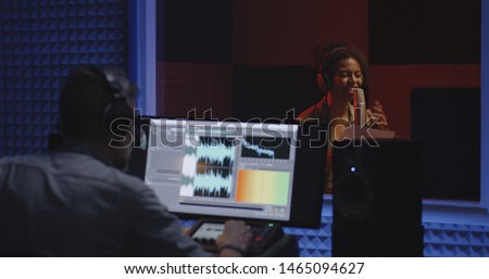 Medium shot of a female actor doing voice over in studio Royalty-Free Stock Photo #1465094627