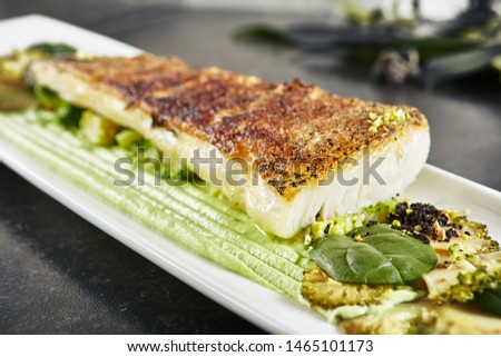Beautiful Restaurant Plate of Baked Halibut Fillet and Broccoli in Different Textures  Close Up. Exquisite Italian Dish of Grilled Flatfish or Sole Fish on Natural Black Stone, Leaves Background