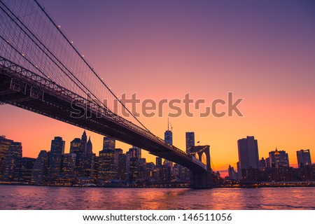 Colorful sunset over New York City skyline and Brooklyn Bridge