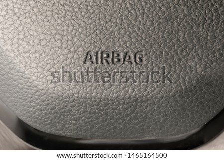 Close up shot of a car's airbag. Close up on car steering wheel with airbag word.