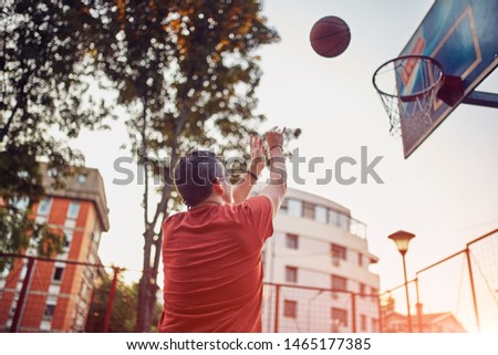 Man taking a shot on a basketball court.