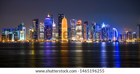 Panoramic night view of West Bay in Doha city. The array of modern skyscrapers can be seen from the corniche. Royalty-Free Stock Photo #1465196255
