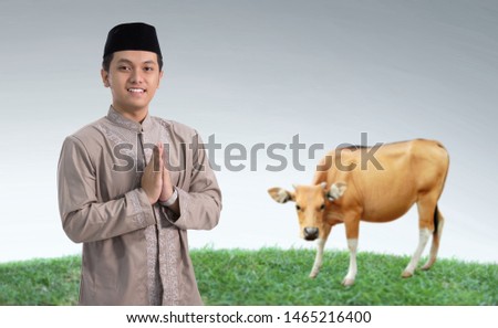 portrait of muslim man with cow for idul adha qurban celebration Royalty-Free Stock Photo #1465216400