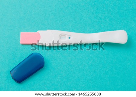 White Plastic Pregnancy Test on blue  Background.