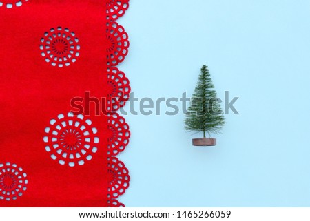 Christmas tree on blue and red background with snowflakes in minimal style. Decorative Christmas ornaments, new year and winter concept. Flat lay, top view, copy space
