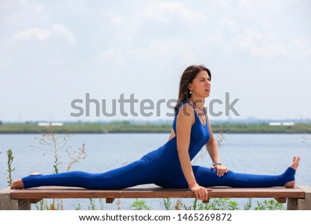 Pretty young woman doing yoga exercise on the nature in the morning.Healthy Concept. Portrait