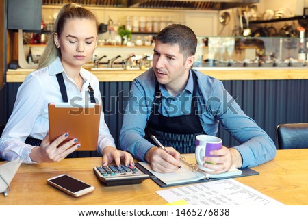 Small family restaurant owners discussing finance calculating bills and expenses of new small business – Stressed man and woman going through paperwork together in cofee shop Royalty-Free Stock Photo #1465276838
