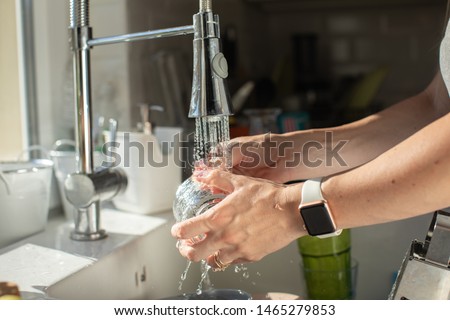 waterproof watch concept. close up of woman hands washing bottle glass. wash the dishes сoncept
