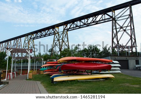Pile of colourful kayaks in the Cap-Rouge waterfront area nautical park installations with a 1908 railway trestle bridge in the background, Quebec City, Quebec, Canada Royalty-Free Stock Photo #1465281194